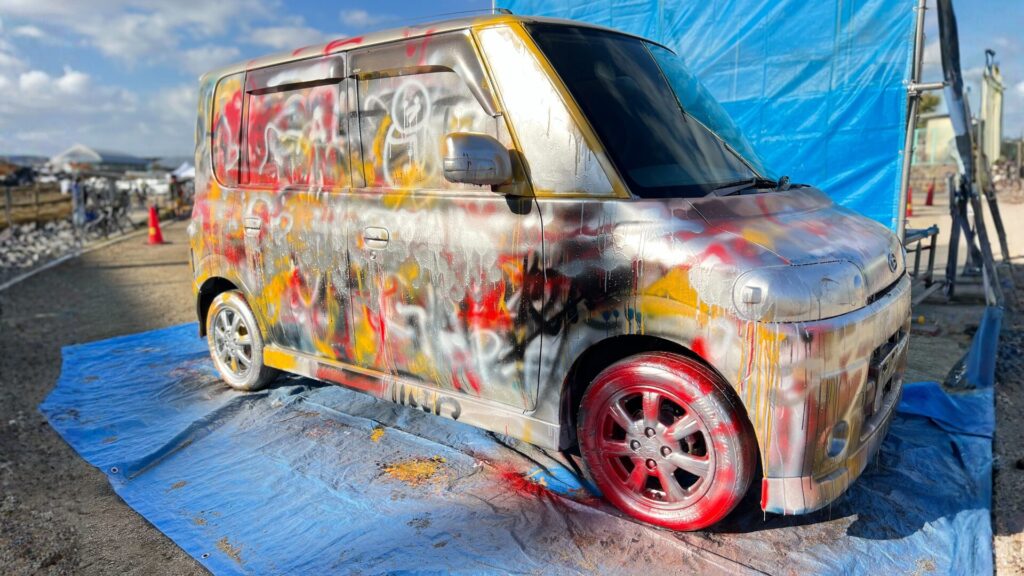 車体にスプレーでペイントやアートを自由に施す板金塗装体験の様子