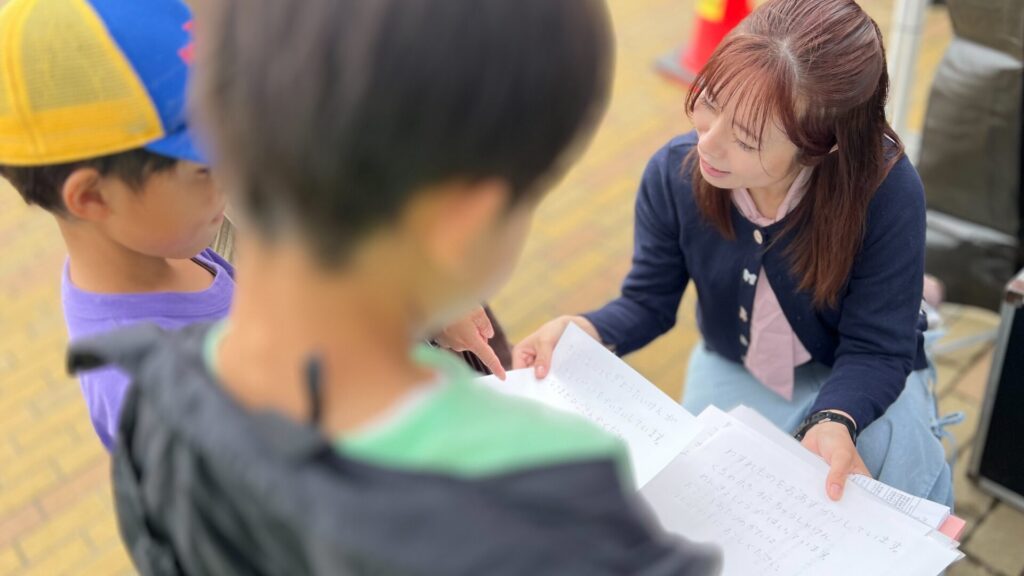 説明を受けながら、アナウンサー体験の台本を真剣な表情で見ている子どもたちの様子